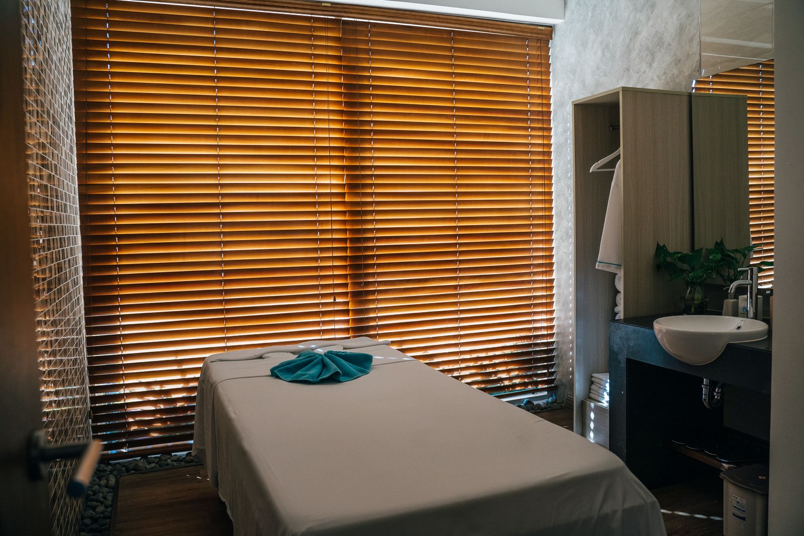 Treatment room at Stillwater Massage Therapy in Burlington, table made up and warm light through the blinds