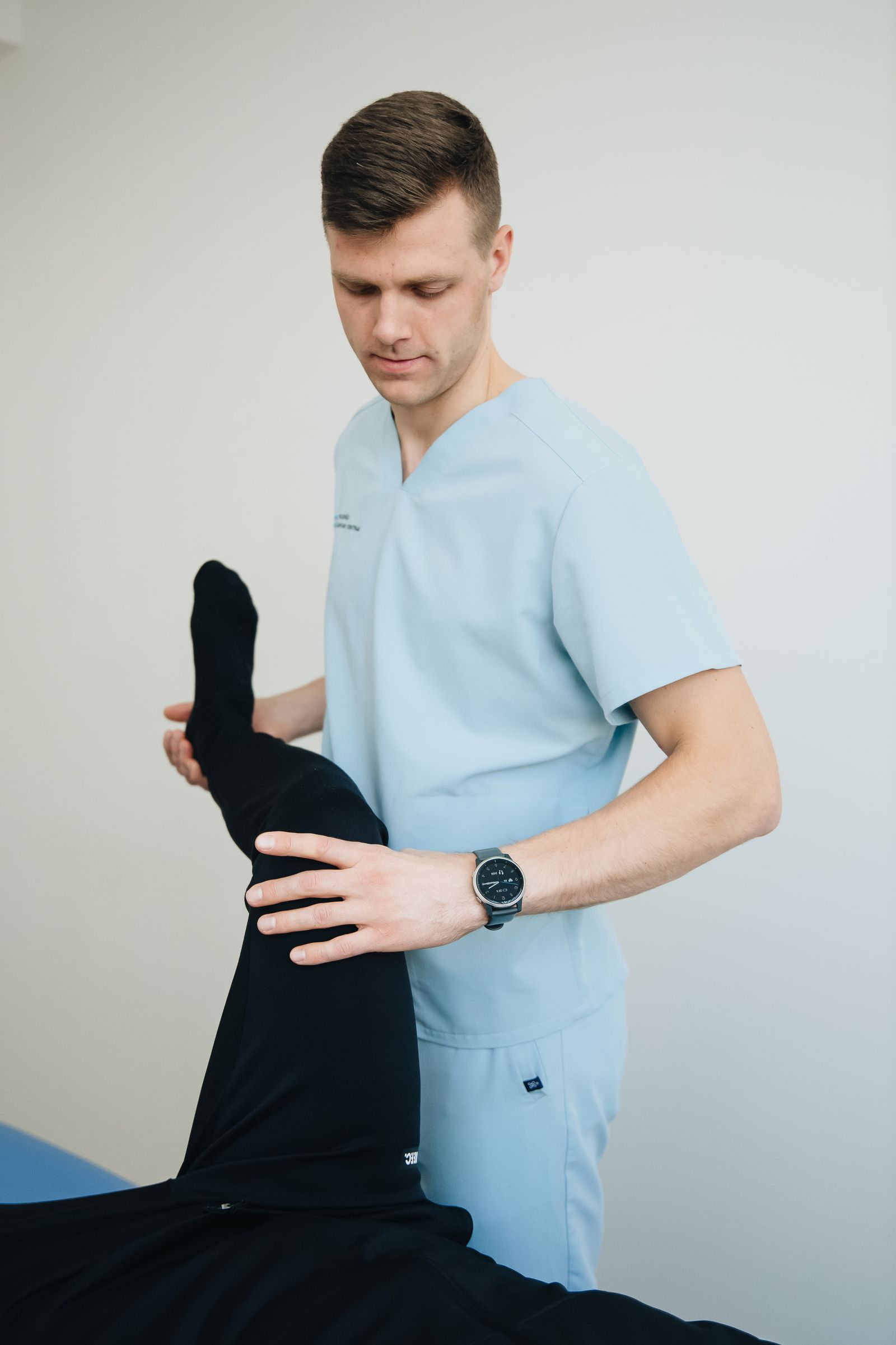 Physiotherapist guiding a supported leg exercise in a Kitchener treatment room